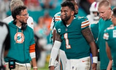 Dolphins head coach Mike McDaniel talks to quarterback Tua Tagovailoa (1) as he leaves the game after suffering a concussion during the second half of Thursday’s game.