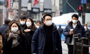 People wearing masks to prevent contracting the coronavirus disease walk on a street in downtown Seoul, South Korea, on 5 January.