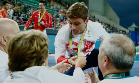 Tom Daley shows his coach Jane Figuereido the bronze medal.