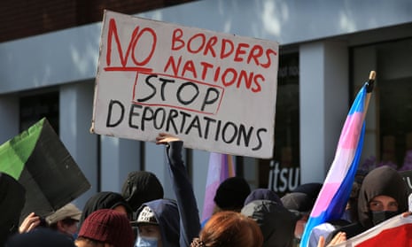 A protester in London holds up a sign saying ‘No Borders No Nations Stop Deportations’.