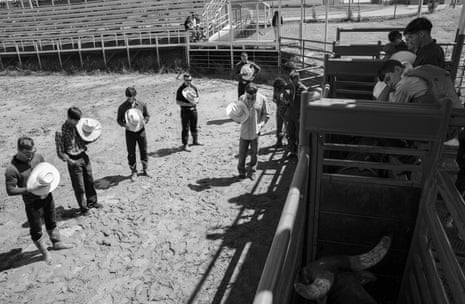 Men holding their cowboy hats and praying successful a rodeo arena