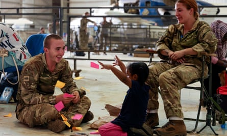 British soldiers with a child due to be evacuated from the airbase at Khartoum.
