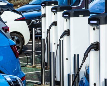 Row of electric cars plugged in to chargers