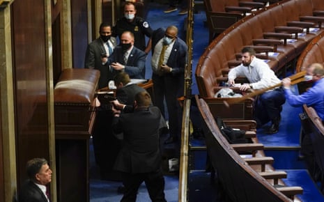 On January 6 2021, Markwayne Mullin, in a white shirt, tried to help Capitol Police officers keep rioters from breaching the barricaded door main door to the House Chamber in the US Capitol.