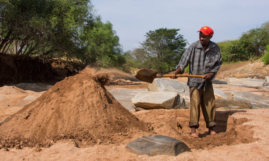 A man harvests sand in Makueni, Kenya.