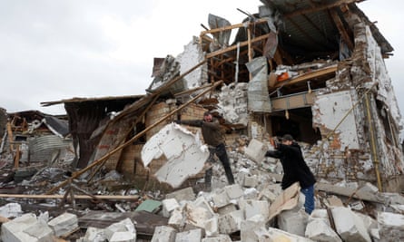 지역 주민들이 2023년 1월 26일 키예프 외곽 흘리바카 마을에서 우크라이나에 대한 러시아의 공세 중에 러시아 군의 공습으로 피해를 입은 이웃집에서 잔해를 치우고 있다.