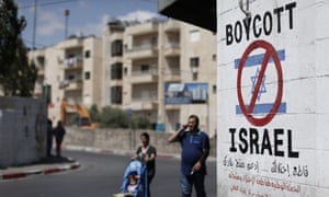 Palestinians walk past a boycott sign in Bethlehem. UK councils are to be told they cannot conduct their own foreign policy campaigns through their procurement and investment policies.