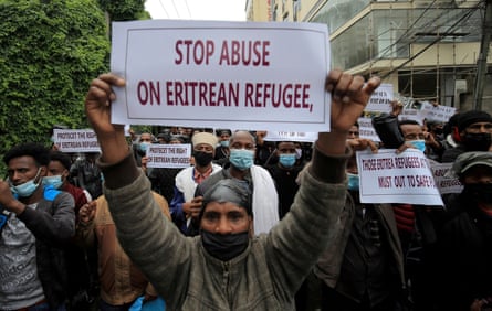 A group of protesters hold up signs, one reads: ‘stop abuse on Eritrean refugee’