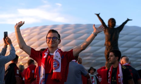 Bayern Munich fans next to the Gerd Muller statue enjoy the atmosphere outside the Allianz Arena ahead of the game against Manchester United.
