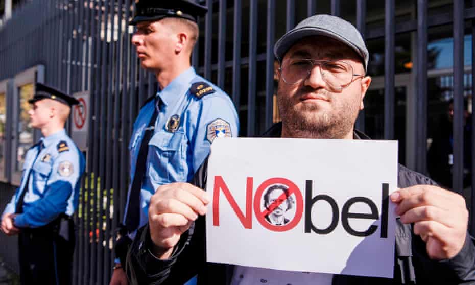 A Kosovo Albanian man holds a placard featuring Peter Handke’s face outside the Swedish embassy during a protest in Pristina on 17 October.