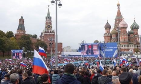 People holding Russian flags gather at Red Square during a ceremony following the annexation of four regions of Ukraine after sham referendums.