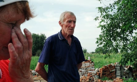 Tamara Leodinivna and Oleksii Oleksiiovych at the site of their ruined home.