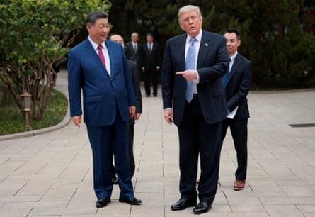 Trump pointing to Xi as the two men stand side-by-side on a pavement