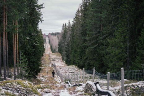 A senior border guard walks along a fence marking the boundary area between Finland and the Russian Federation near the border crossing of Pelkola, in Imatra, Finland. Photo taken on 18 November 2022.