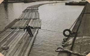 A raftsman manoeuvring floating timber