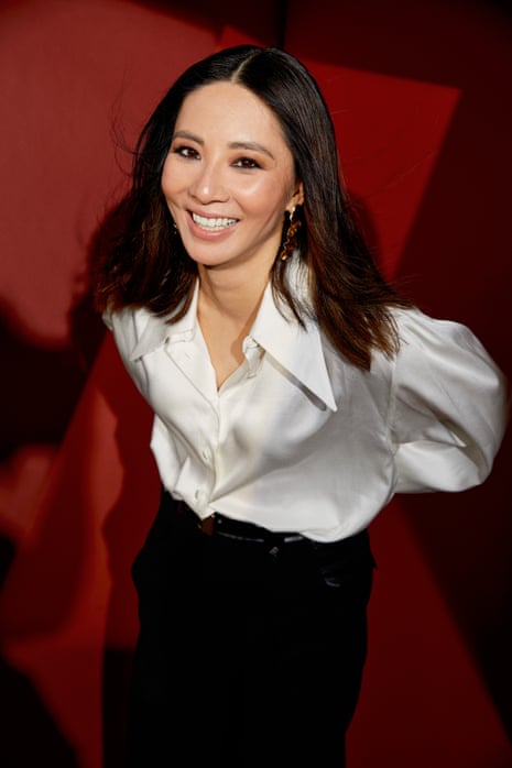 Jing Lusi in a white blouse on a red background.
