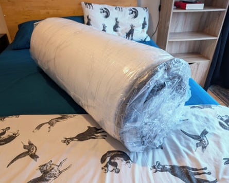 The Emma Hybrid Premium Mattress rolled up and in plastic.