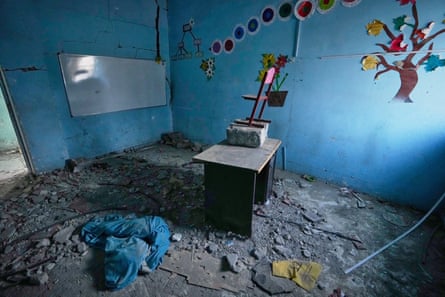 Colorful tree and flower decorations remain on the walls of a rubble-strewn classroom at Shajareh Tayyebeh school, damaged in a U.S. airstrike