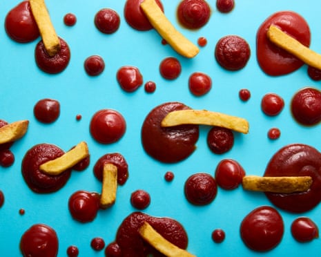 French fries and pools of ketchup in various sizes arranged on a blue surface