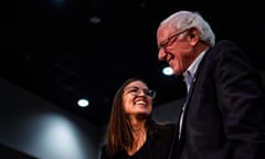 Alexandria Ocasio-Cortez and Bernie Sanders smile at each other
