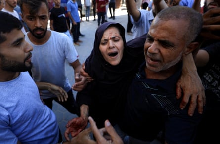 Palestinians assist a wounded woman, after an Israeli strike on a tent, at al-Aqsa Martyrs hospital in Deir al-Balah, central Gaza, on Wednesday.