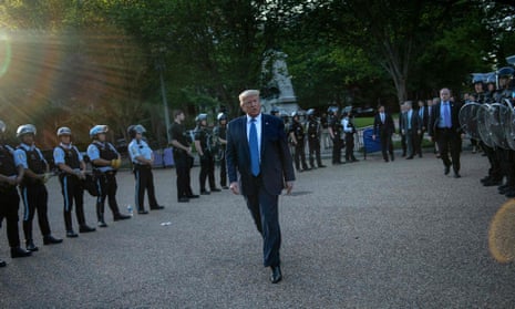 Trump is flanked by police as he walks from the White House to nearby St John’s Episcopal church on Monday.
