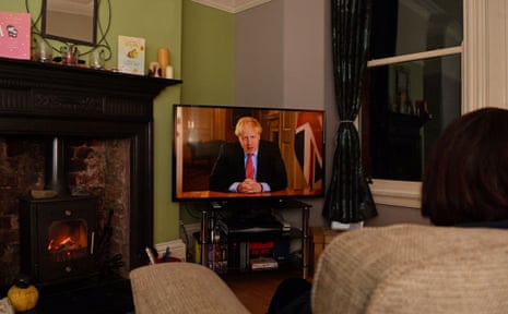 Members of a family listen as Britain’s Prime Minister Boris Johnson makes a televised address to the nation from inside 10 Downing Street in London, with the latest instructions to stay at home to help contain the Covid-19 pandemic, from a house in Liverpool, north west England on March 23, 2020.