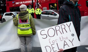 Climate protesters from the Extinction Rebellion group hold placards and banners as they block traffic in Elephant and Castle