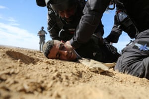 Israeli security forces detain a Bedouin man during a protest against forestation at the Negev desert village of Sawe al-Atrash.