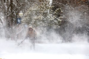 Jeff Zimmerman clears the walkways on the Lewis-Clark State College campus of snow with a leaf blower on Tuesday, Dec. 28, 2021, in Lewiston, Idaho. (August Frank/Lewiston Tribune via AP)