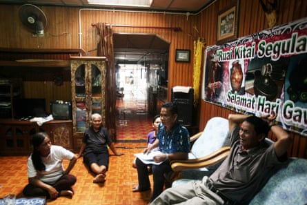 Environmentalist Jok Jau Evong (far right) and headman Gasah Anak Tadong (right, in chair) meet with community members in the Sungai Buri longhouse