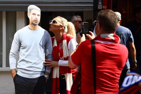 An Arsenal fan with a cardboard cutout of manager Mikel Arteta outside the stadium before the match