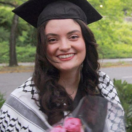 A young woman wears a graduation capa nd a keffiyeh