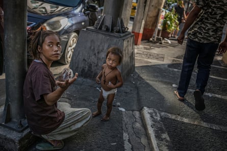 A homeless woman in Malate seeks change to buy food for her toddler. The streets of Manila are home to thousands of homeless Filipinos who sleep on the sidewalks, sea walls, under awnings and in stairwells - anywhere they can get rest without being told to move on