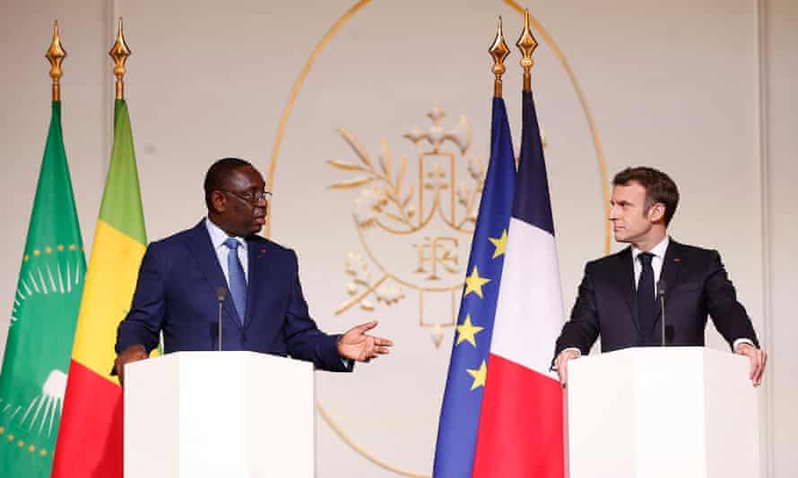 Emmanuel Macron e o presidente do Senegal, Macky Sall, em frente a bandeiras