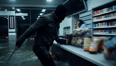 A man robs a petrol station as a staff member cowers in terror