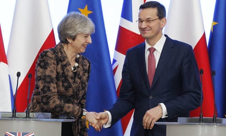 Polish Prime Minister Mateusz Morawiecki, right, and Britain’s Prime Minister Theresa May shake hands during a press conference in Warsaw