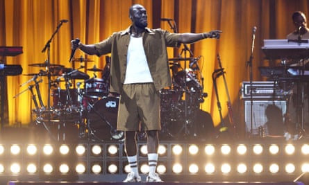 Stormzy على خشبة المسرح يمد ذراعيه للجمهور.