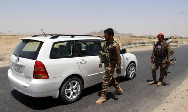 Afghan army soldiers search vehicles at a checkpoint on a highway leading to the Maiwind district of Kandahar.