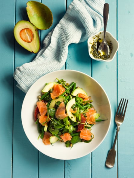 Healthy summer salad with watercress, sun-dried tomatoes, green beans, smoked salmon, capers, and avocado.