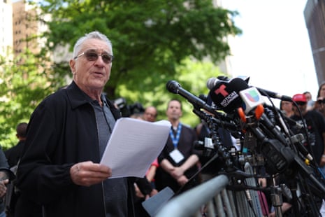 man wearing sunglasses speaks to reporters