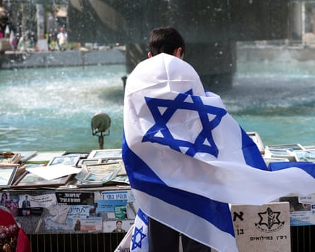 Back view of boy wrapped in Israeli flag