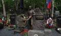 A man kneels at the statue of Yevgeny Prigozhin at his grave in St Petersburg, Russia