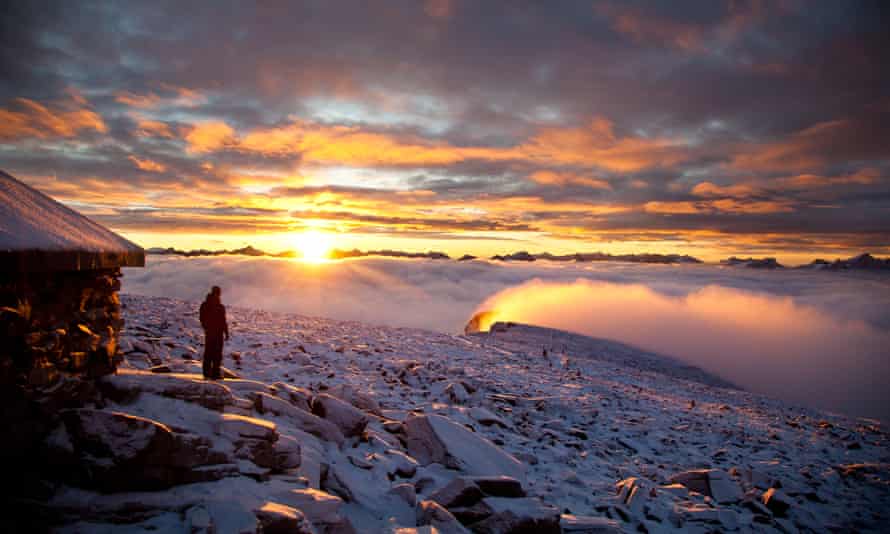 Une figure solitaire au lever du soleil dans un paysage enneigé en Norvège