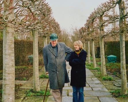 Father and daughter walking down an avenue of trees