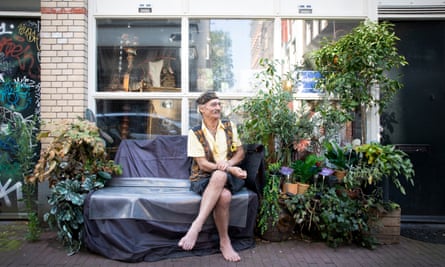 Karoly Almoes outside his house on a bench surrounded by plant pots