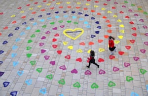 Bristol, England. Children run over a new public artwork featuring 1,000 rainbow coloured hearts, which has been unveiled at Cabot Circus shopping centre