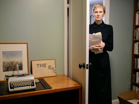 Author Siri Hustvedt in the doorway of an office, typewriter on desk, papers in her hands