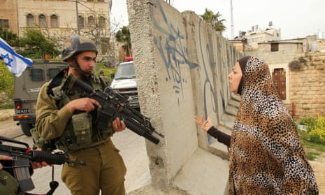 A Palestinian woman speaks with an Israeli soldier in Hebron, March 2016