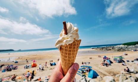 POV wide angle view of a hand holding Ice cream cone at Fistral Beach, Newquay on a sunny June day.
